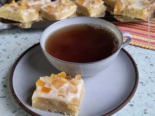 Tivoli-Kekse - Tivolikakor im Hintergrund. Eine Tasse Tee auf der Untertasse liegt ein Tivolikeks