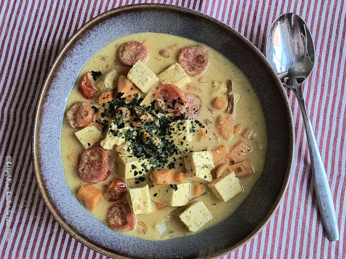 Ein Teller mit Massaman-Curry mit Süßkartoffel bestreut mit Koriander
