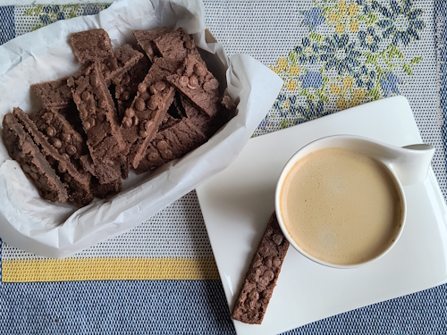 Schokoschnitten - Mjölkchokladsnittar angerichtet in einem Behälter und neben einer Tasse Kaffee