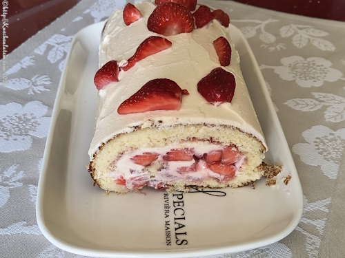 Anschnitt einer Erdbeer-Biskuitrolle mit Mascarpone auf einem Tablett angerichtet