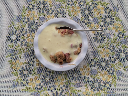 Dessertschale mit Rhabarber Crisp und Vanillesoße mit Teelöffel