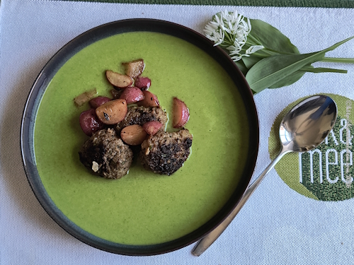 angerichteter Teller Bärlauch-Kartoffel-suppe mit Frikadellen und Radieschen