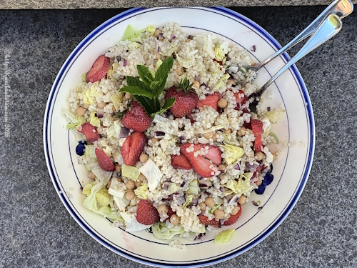 Schüssel mit Graupensalat mit Kichererbsen, Erdbeeren und Rhabarber Dressing und Salatbesteck